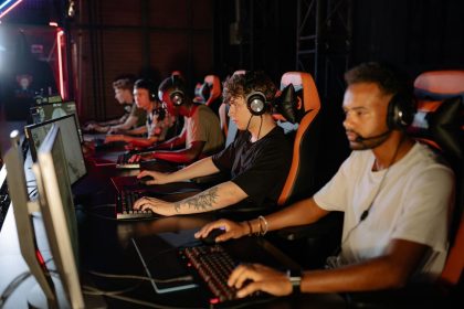 Jogadores concentrados disputam uma competição de futebol eletrônico em uma arena de esports.